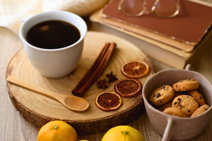 warm drink on table with dried oranges and cookies